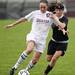 Dexter senior Olivia Vollmers runs with the ball as Huron sophomore Brenna Barton defends on Tuesday, April 23. Daniel Brenner I AnnArbor.com